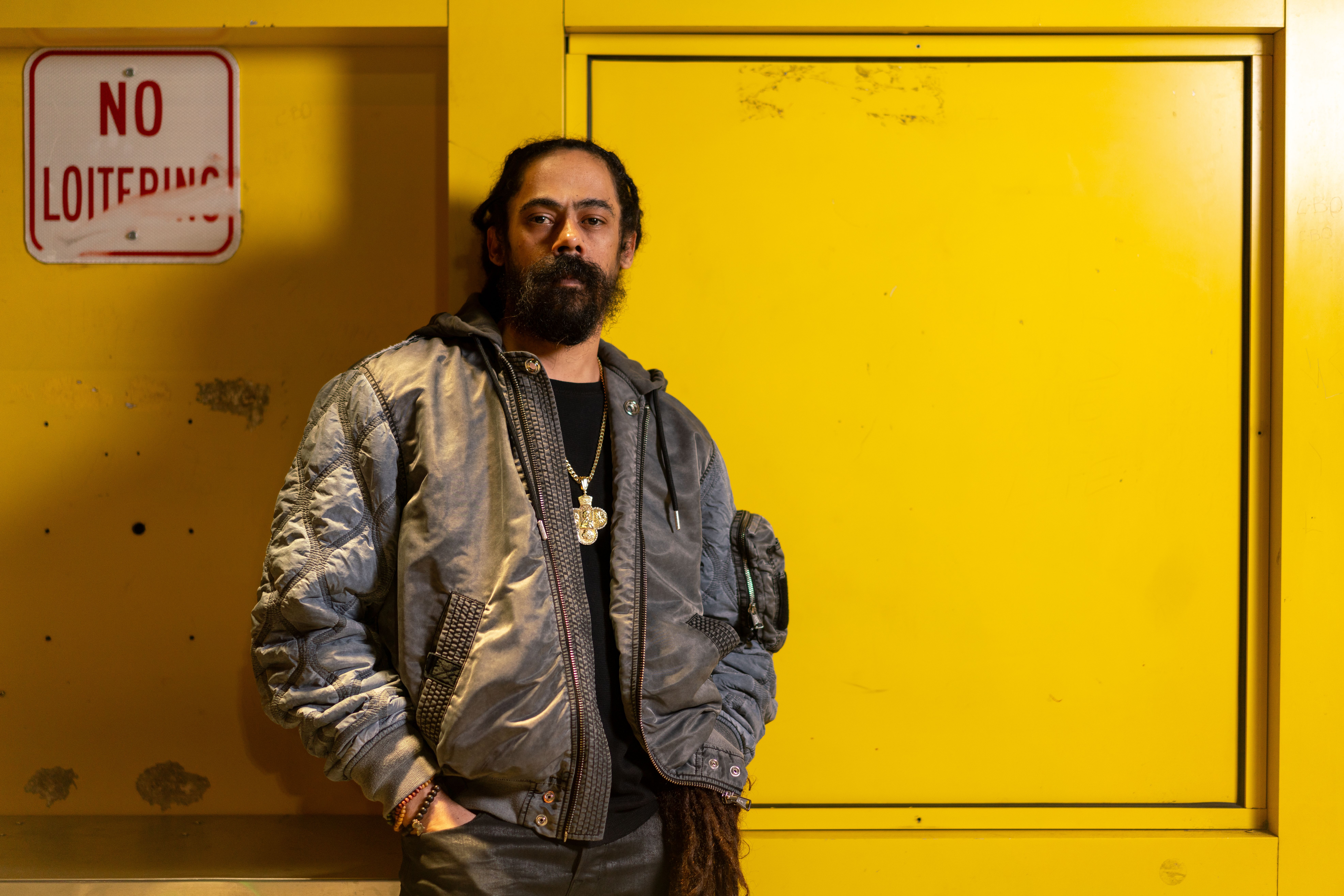 Damian Marley standing in front of yellow wall