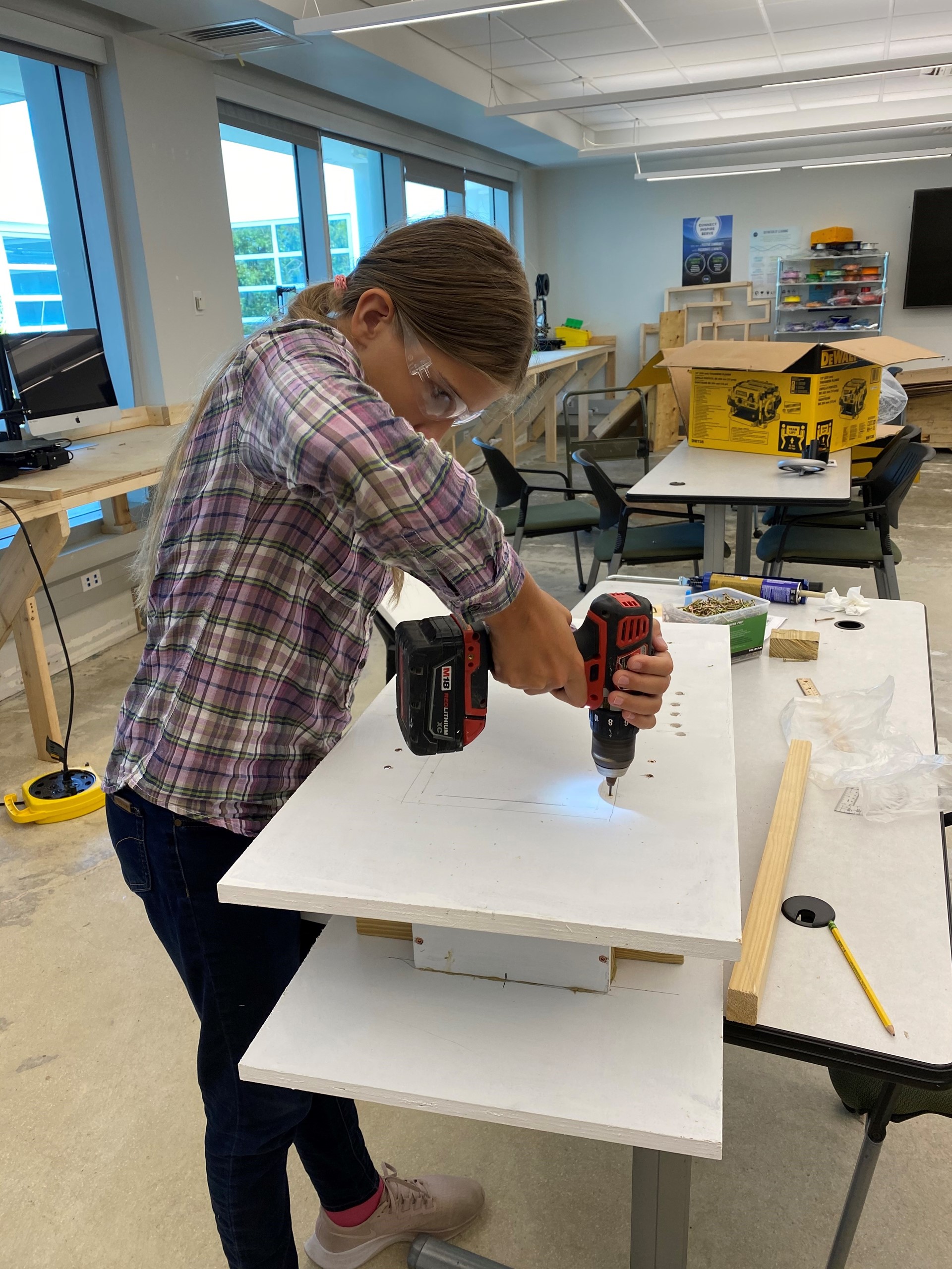 young girl building bat house