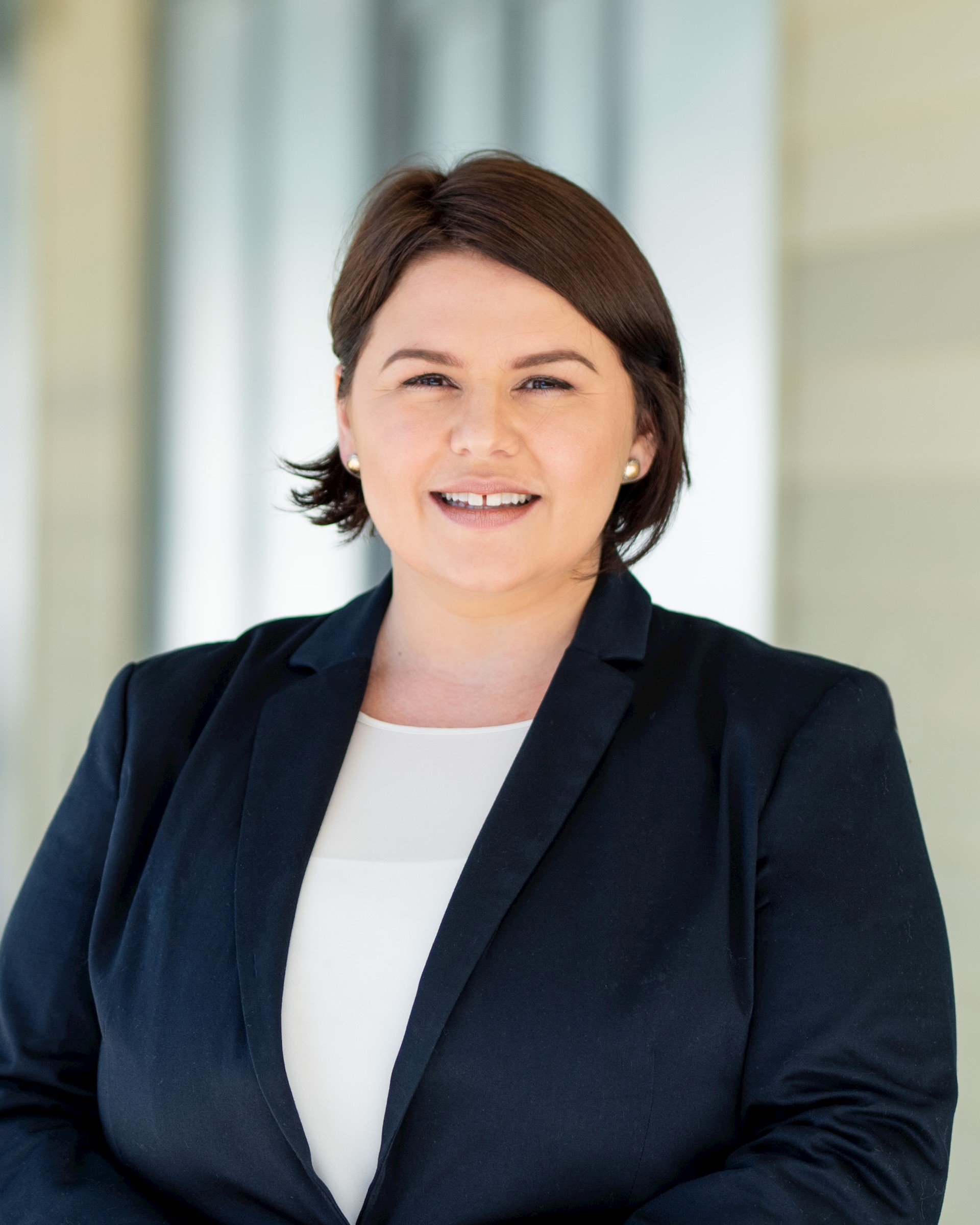 White woman in blazer smiling at camera