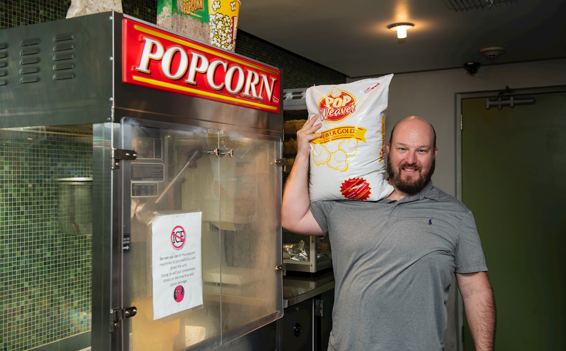 cinema manager holding popcorn bag