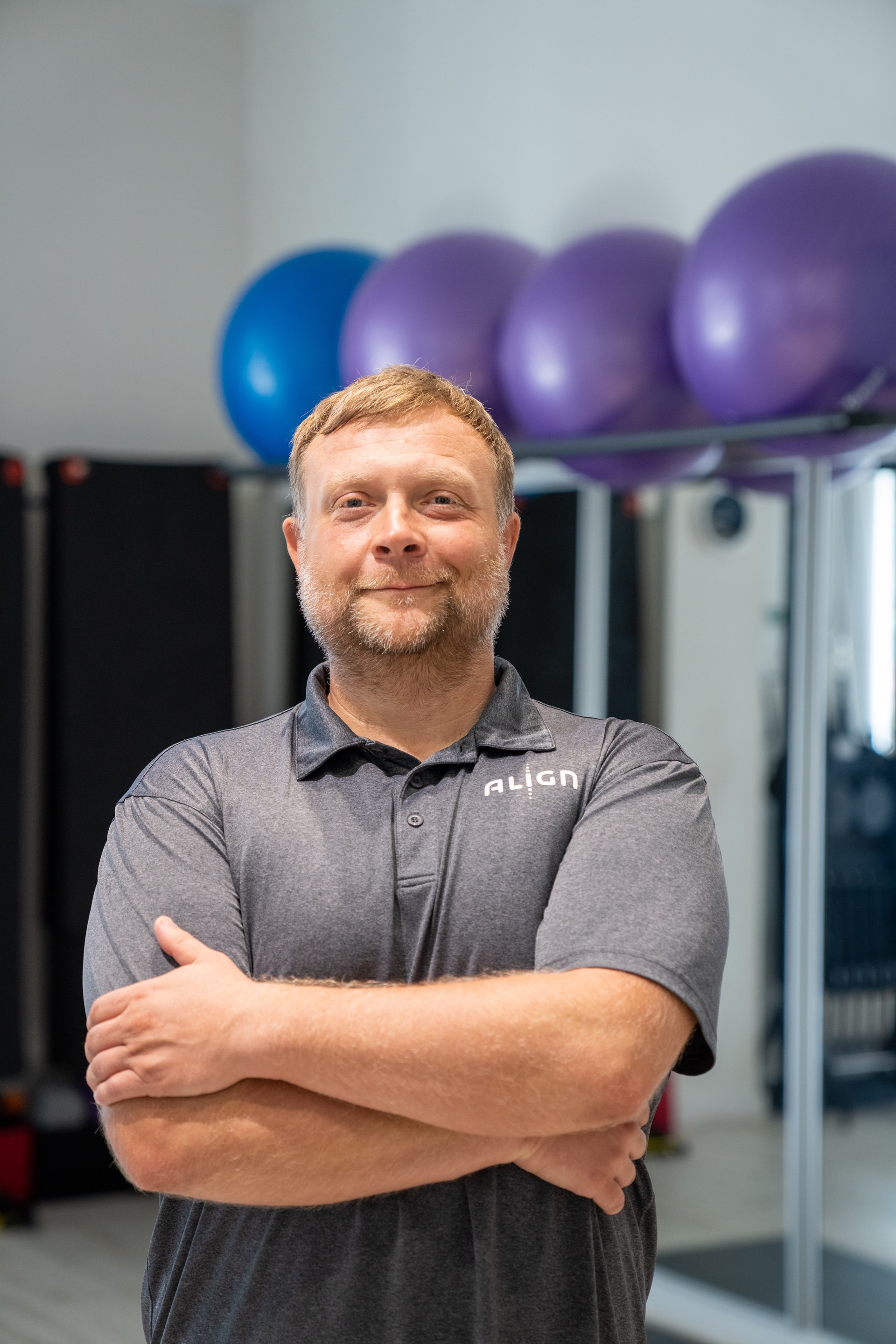 White man smiling at camera with arms crossed