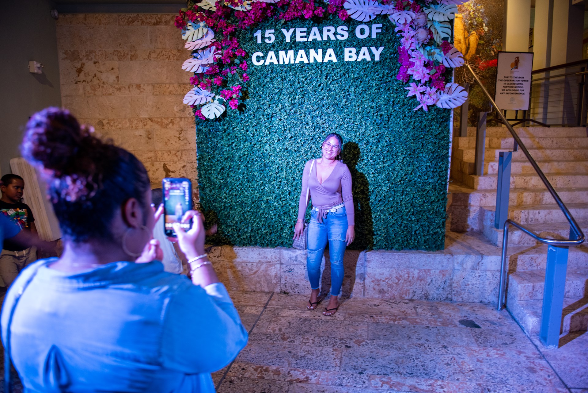 Woman takes picture in front of backdrop