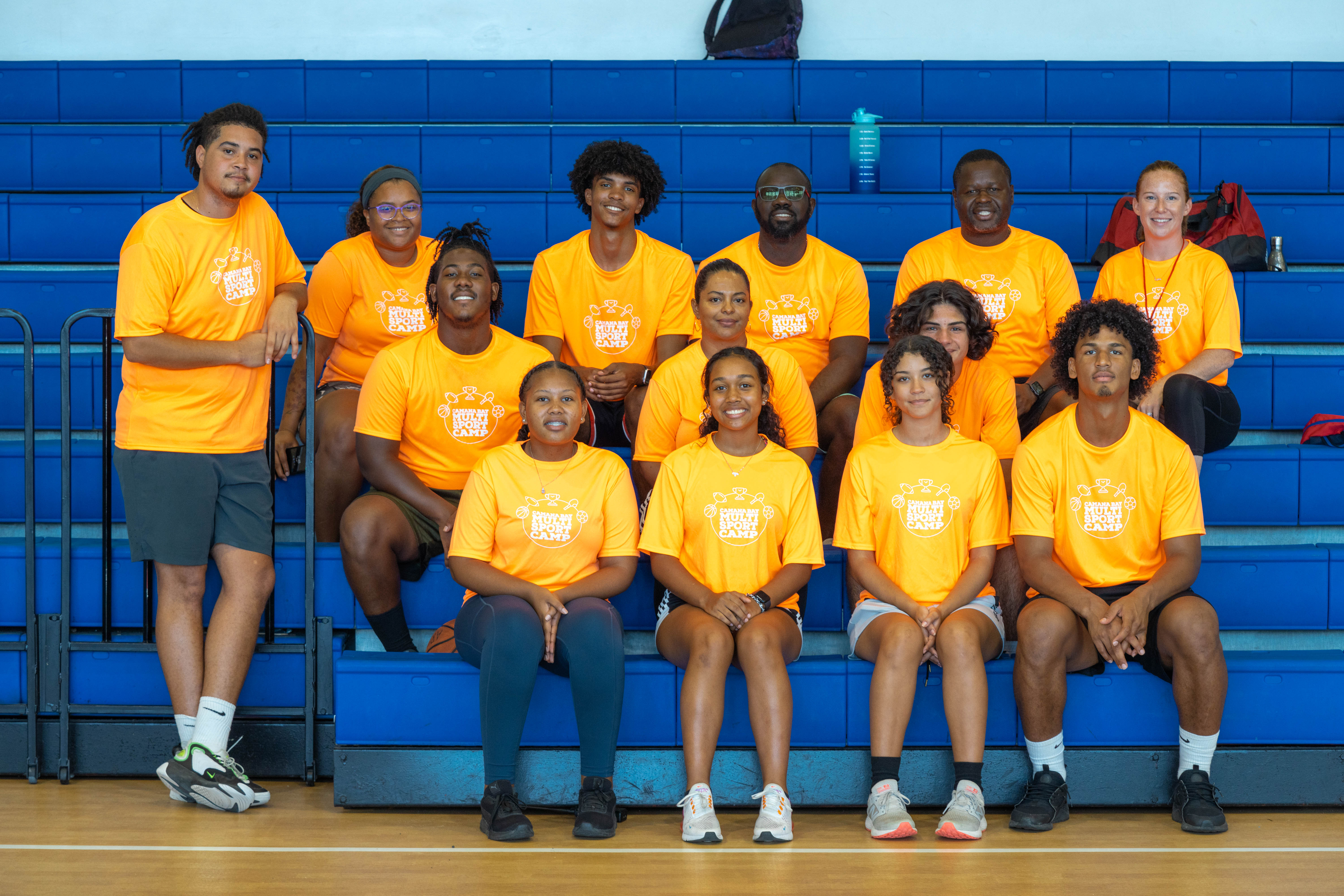 young basketball players with a coach, posing on bleachers