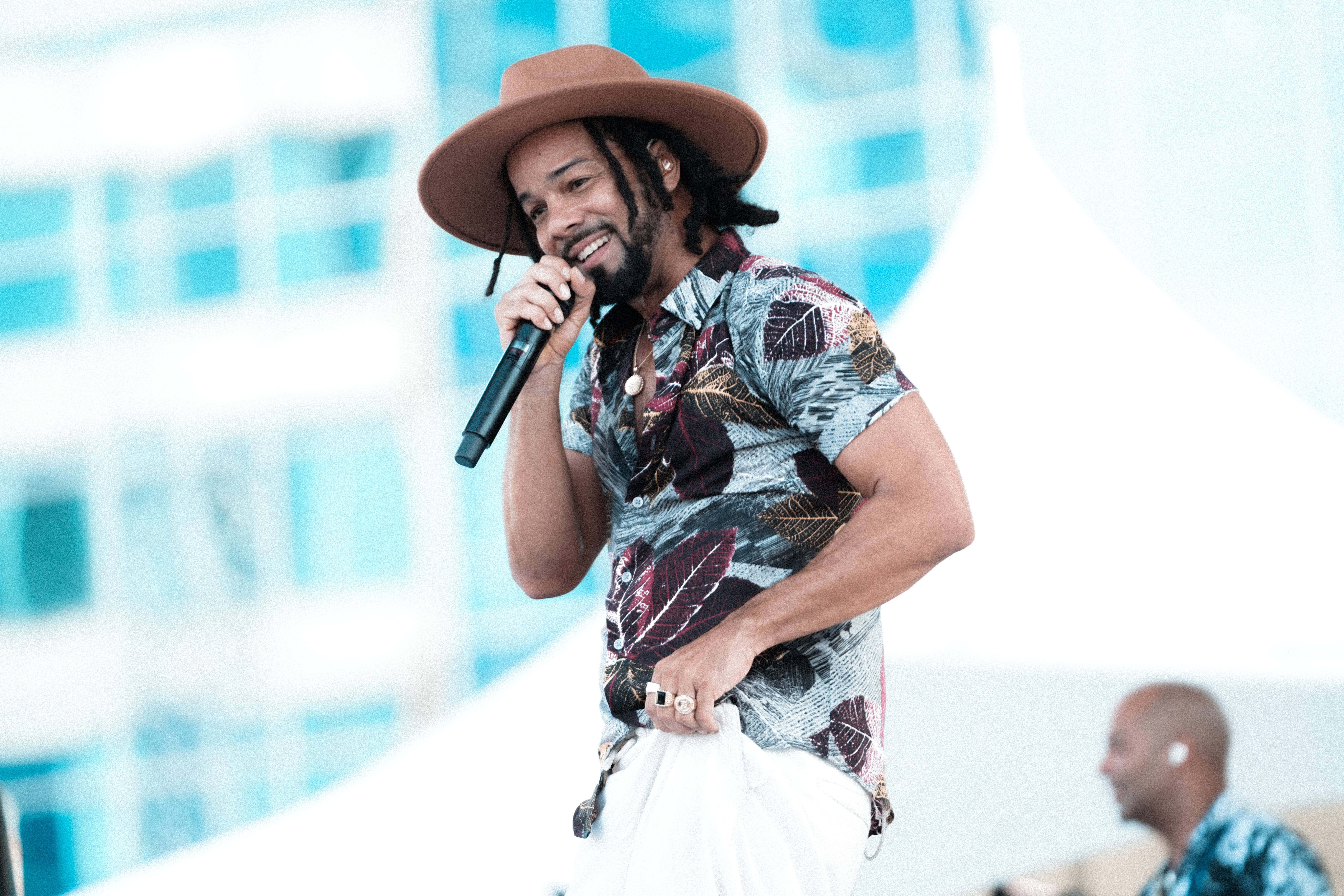 Man with dreads and hat singing